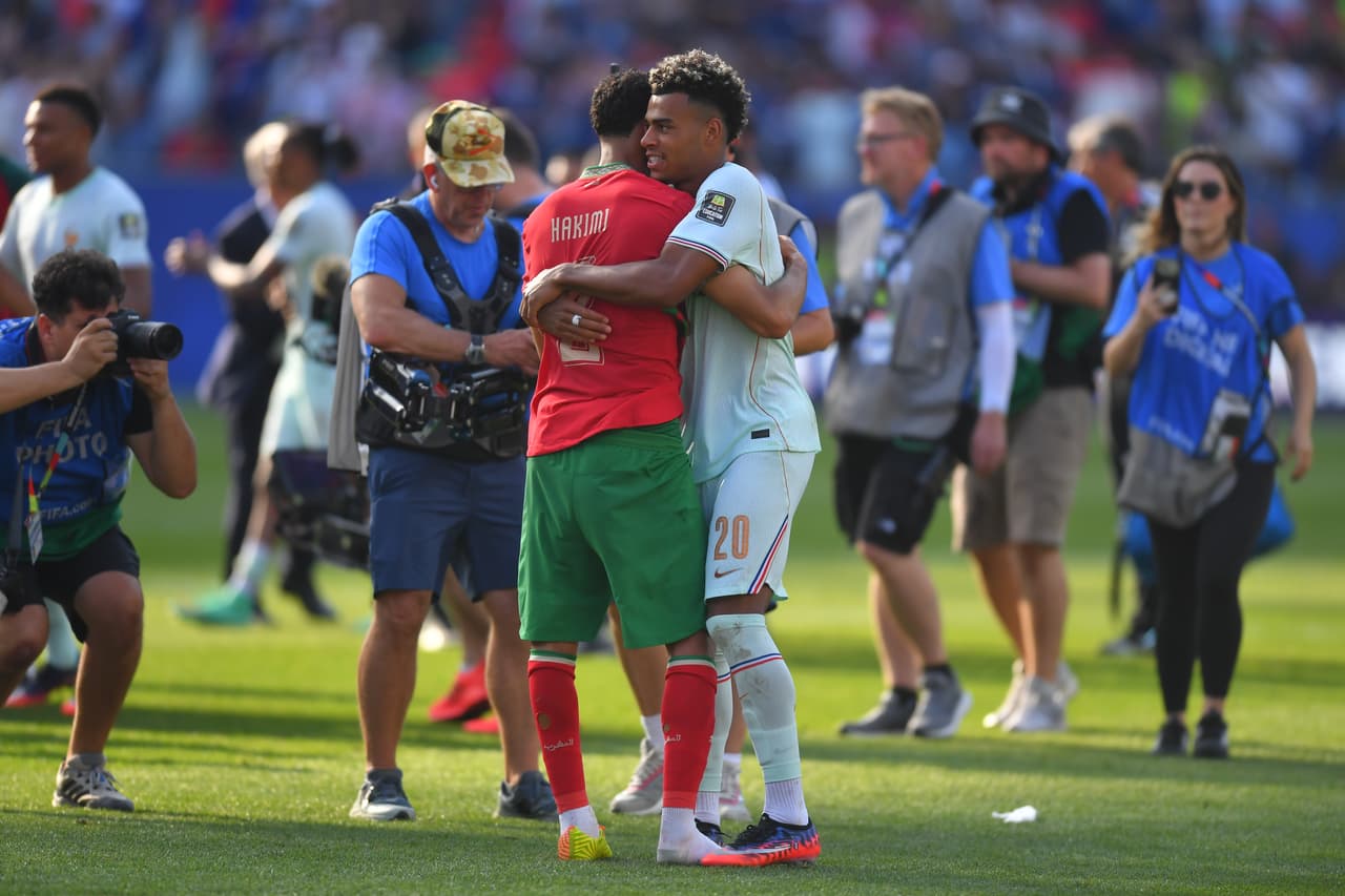 Achraf Hakimi y Desire Doue se despiden en el campo.