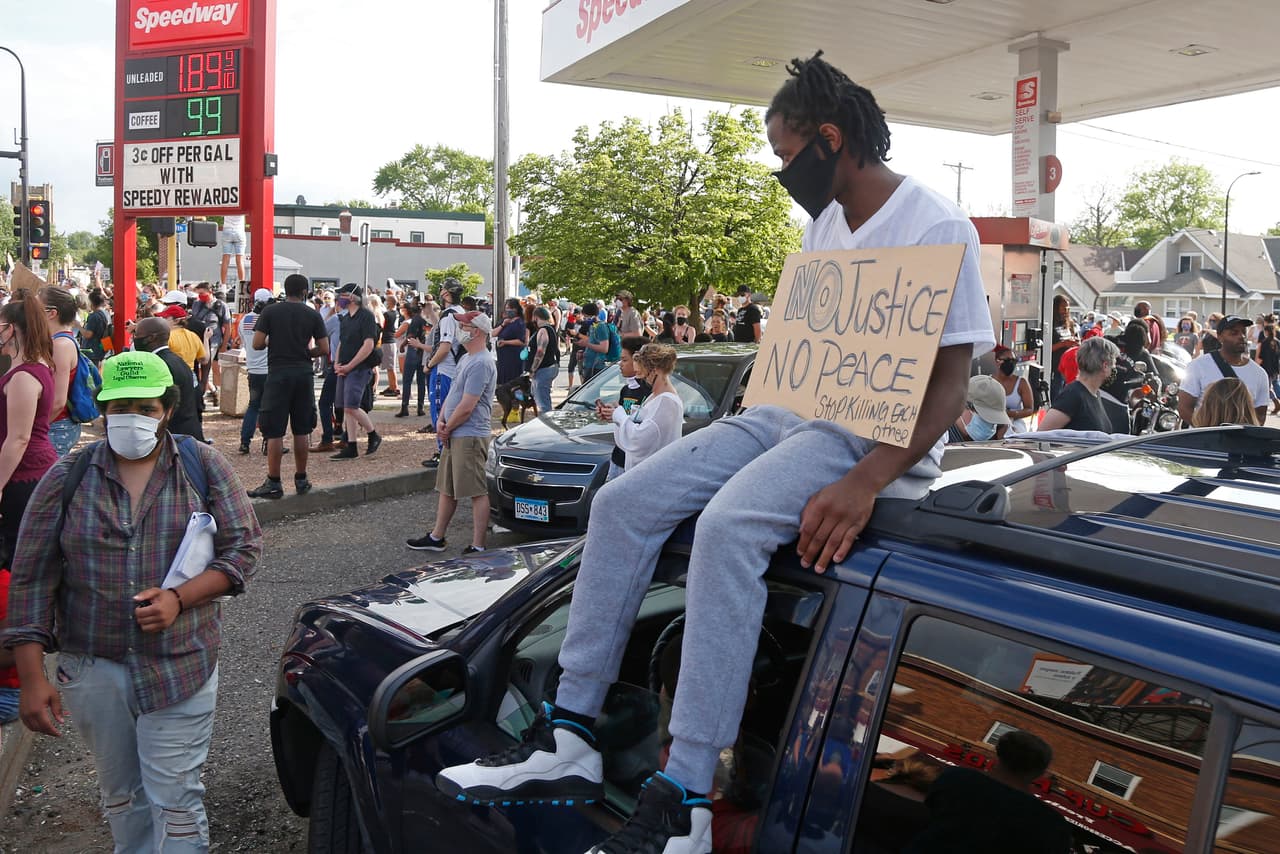 Un manifestante se sienta en la parte superior de un vehículo mientras cientos de personas protestan por el caso de George Floyd, que ha estremecido a la comunidad afroestadounidense de Minneapolis.