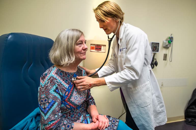 La doctora Rice chequea la respiración de Mary Heafy durante un examen de asma en la Beth Israel Deaconess Clinic. Rice le dijo a Heafy que el cambio climático parece estar extendiendo la temporada de alergias en el área de Boston.
<br>