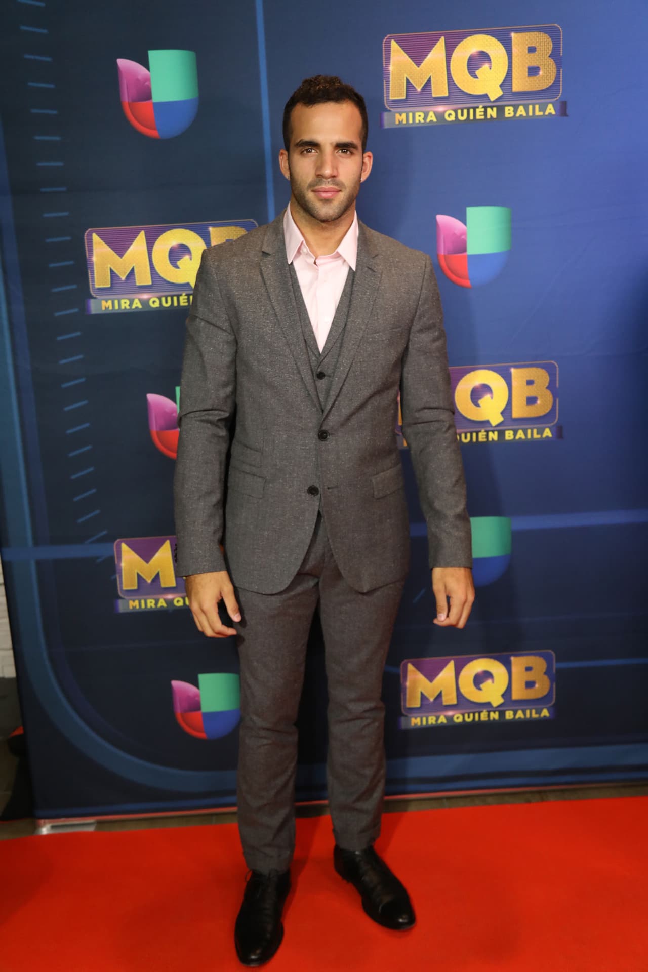 El gimnasta optó por un traje gris con una camisa rosada.