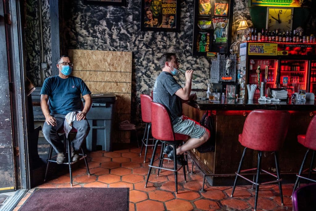 Un bar en Austin y dos clientes con mascarillas.