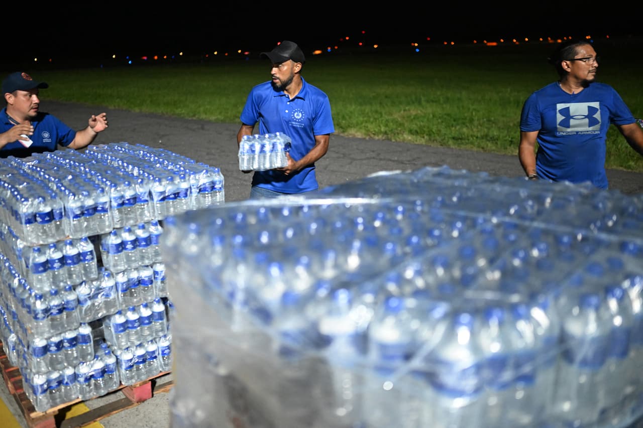 Empleados del gobierno salvadoreño preparan palés con agua embotellada para cargarlos en un avión con ayuda humanitaria con destino a Jamaica, por orden del presidente de El Salvador, Nayib Bukele, tras el paso del huracán Melissa. La fotografía fue tomada en la pista del Aeropuerto Internacional San Óscar Romero en San Luis Talpa, El Salvador, el 31 de octubre de 2025.