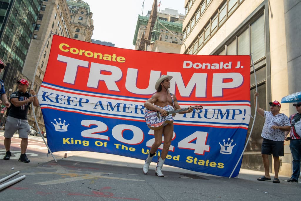 <b>Robert John Burck</b>, quien se ha dado a conocer en la ciudad de Nueva York como 'El Vaquero Desnudo'
<b><a href="https://www.univision.com/shows/el-gordo-y-la-flaca/raul-enfurece-al-ver-la-agresion-de-la-que-fue-victima-el-naked-cowboy-por-tocar-canciones-en-apoyo-de-trump-video" target="_blank">(Naked Cowboy) se sumó a los manifestantes, cantándole a Donald Trump</a></b> horas después del atentado. El popular personaje nunca ha ocultado que confía en el expresidente republicano.