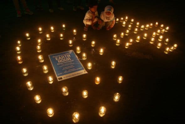Estos niños se sientan junto a unas velas encendidas también en Java Oriental.