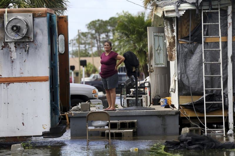 Elida Dimas looks at floodwaters from her porch, in the aftermath of Hurricane Irma, in Immokalee, Fla. Irma badly damaged Dimas’ mobile home and destroyed another she and her husband used for rental income, making their tough life even harder. (AP Photo/Gerald Herbert)