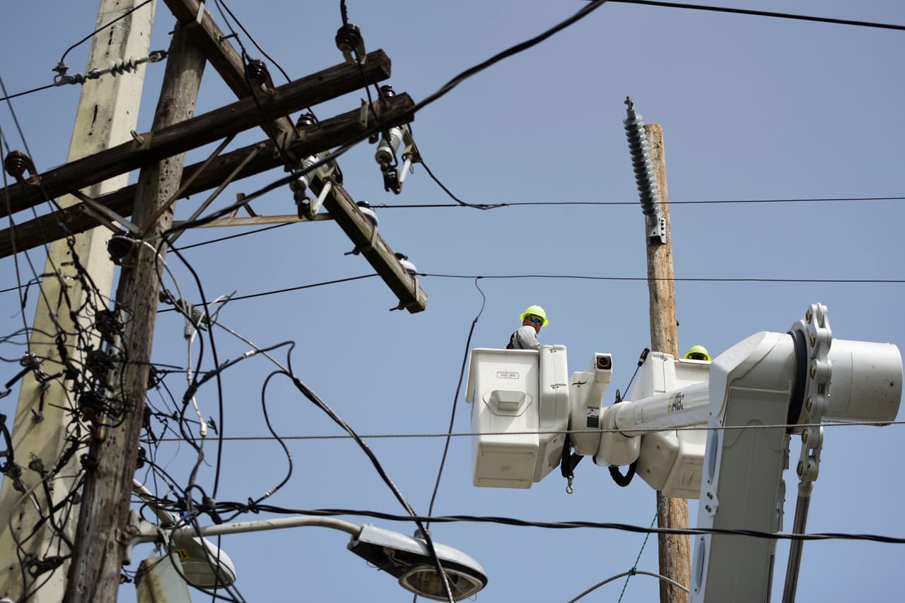 ARCHIVO - En esta fotografía de archivo del 19 de octubre de 2017, una cuadrilla de la Autoridad de Energía Eléctrica repara tendidos dañados por el huracán María en el sector de Cantera en San Juan, Puerto Rico. (AP Foto/Carlos Giusti, Archivo)