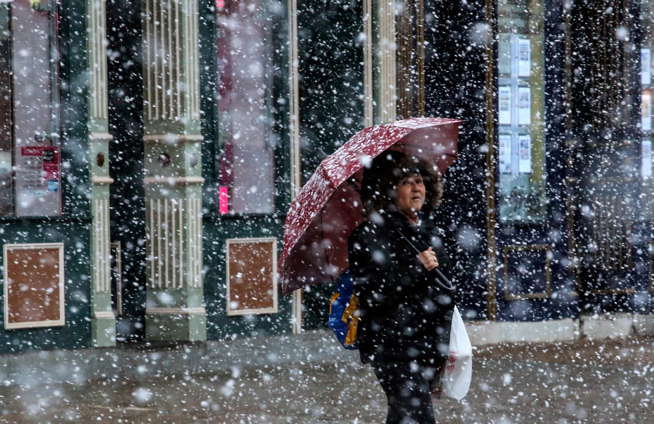 Una mujer espera para cruzar la calle bajo la nieve en Hoboken, Nueva Jersey. Las autoridades advierten que las nevadas están acompañadas de tormentas eléctricas.