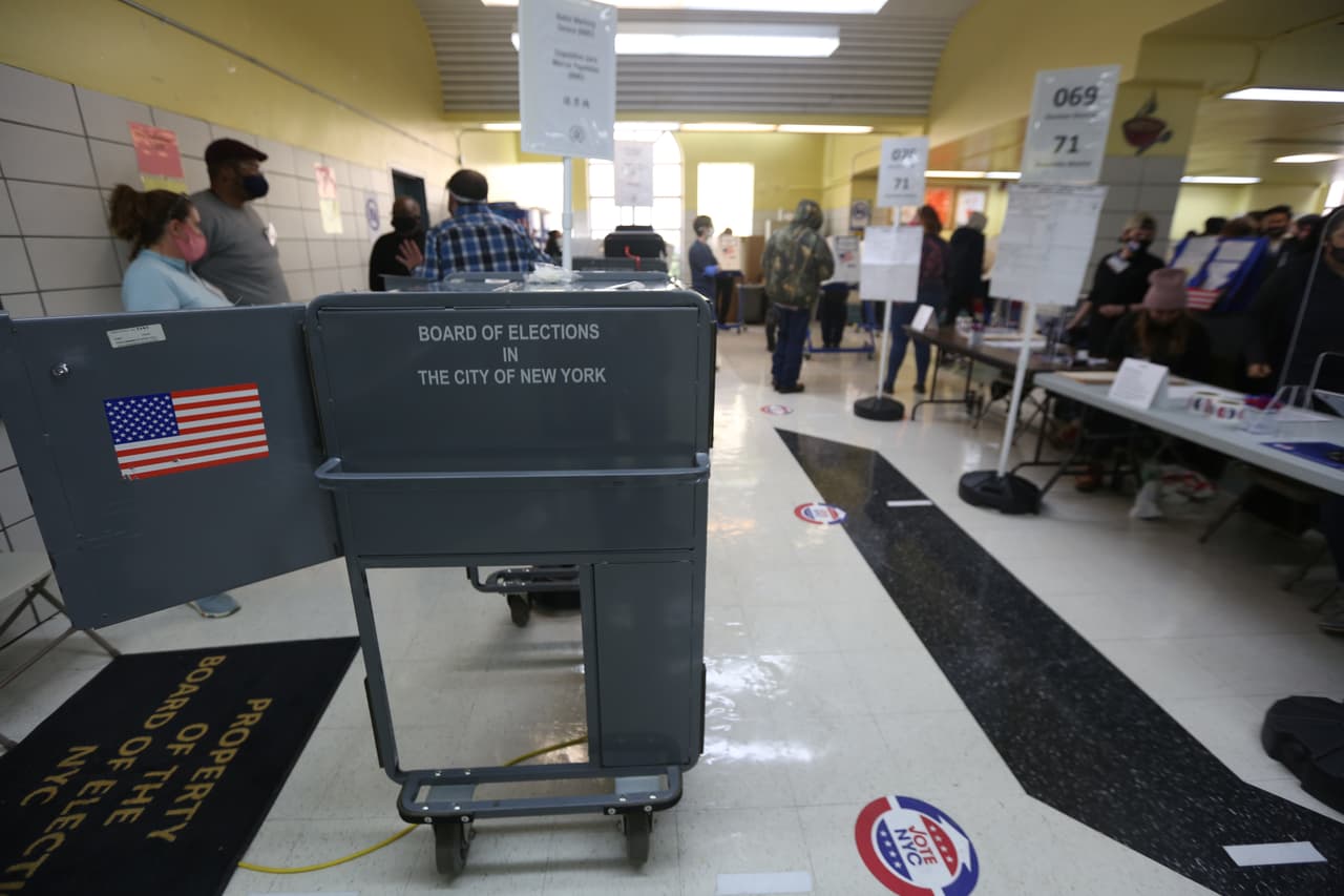 Escuela PS 173 en la calle Oeste 174 de Manhattan voluntarios y votantes mantienen la distancia social mientras esperar su turno para votar.