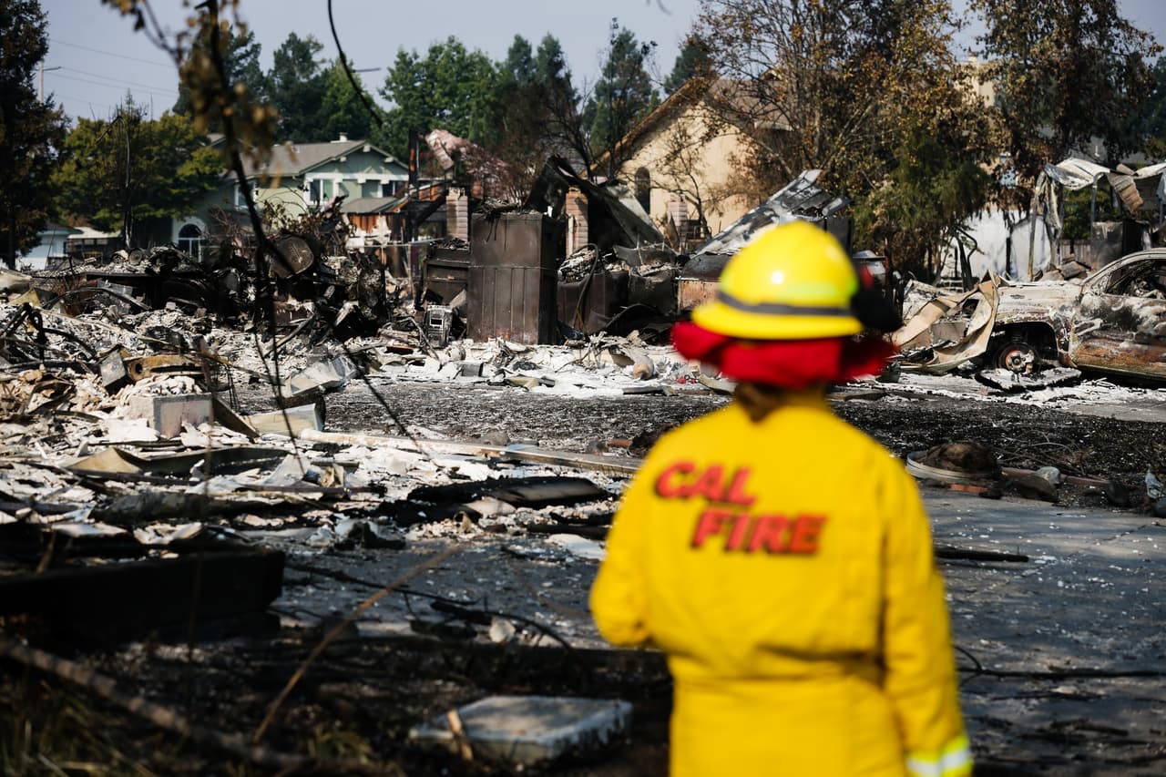Un empleado de Cal Fire examina el daño en el vecindario de Coffey Park.