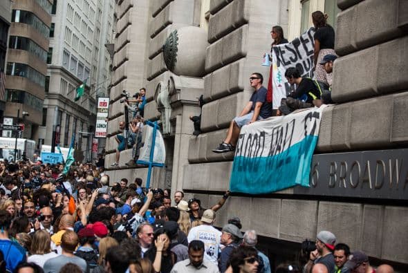 Algunos manifestantes se apostaron en edificios aledaños para desplegar mantas contra el cambio climático.