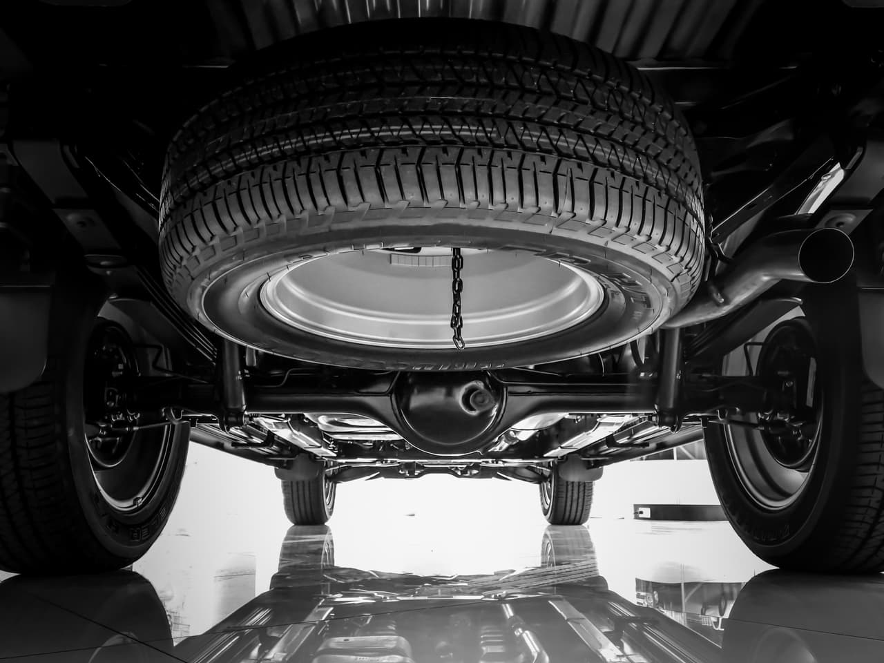 4. 
<b>Localiza y remueve el neumático de emergencia.</b> 
<br>
<br>Normalmente esta bajo el piso del baúl, pero en algunos casos, especialmente en la camionetas, lo vas a encontrar debajo del vehículo. Consulta el manual de tu carro.