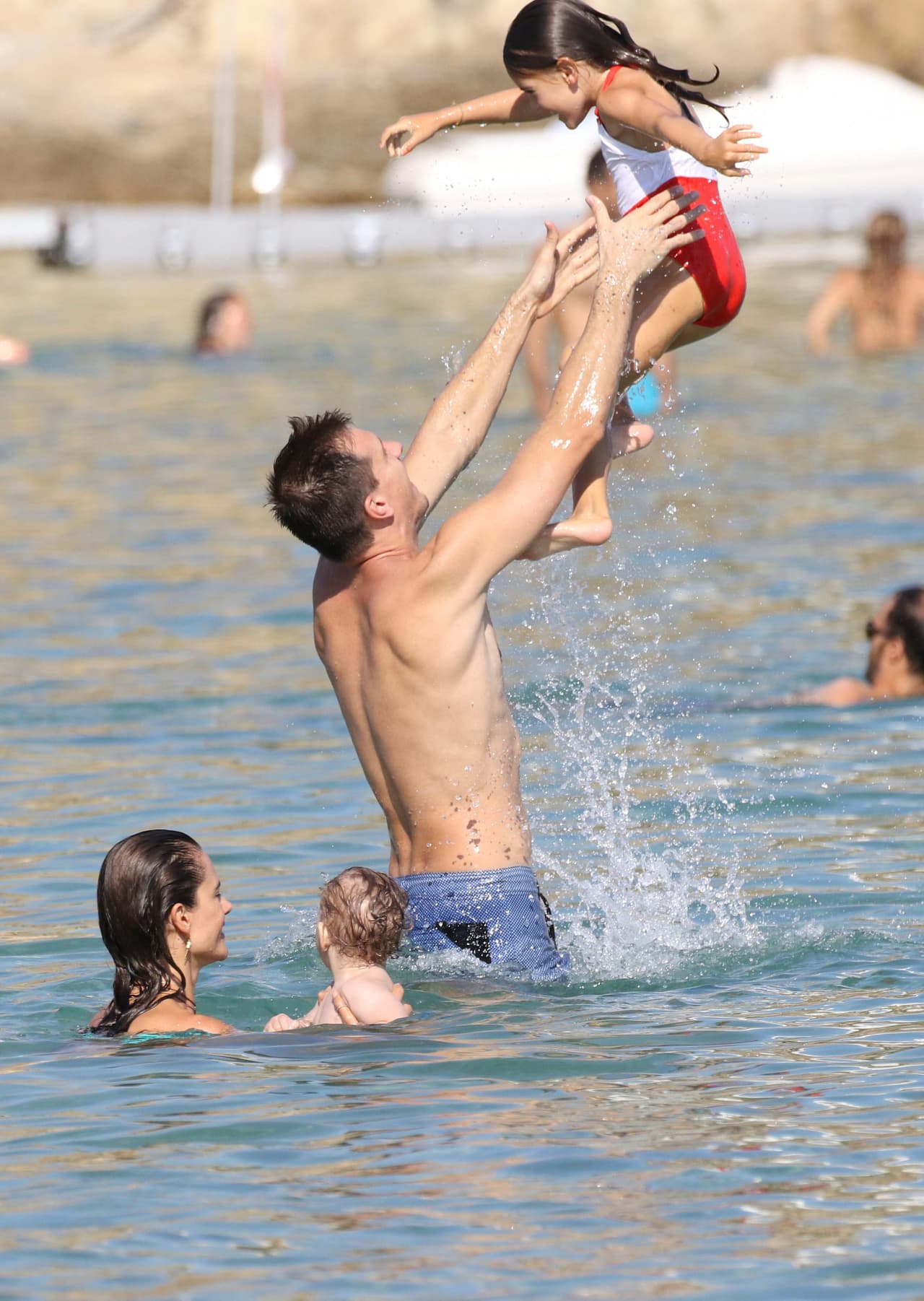 Alzando a la pequeña al aire.