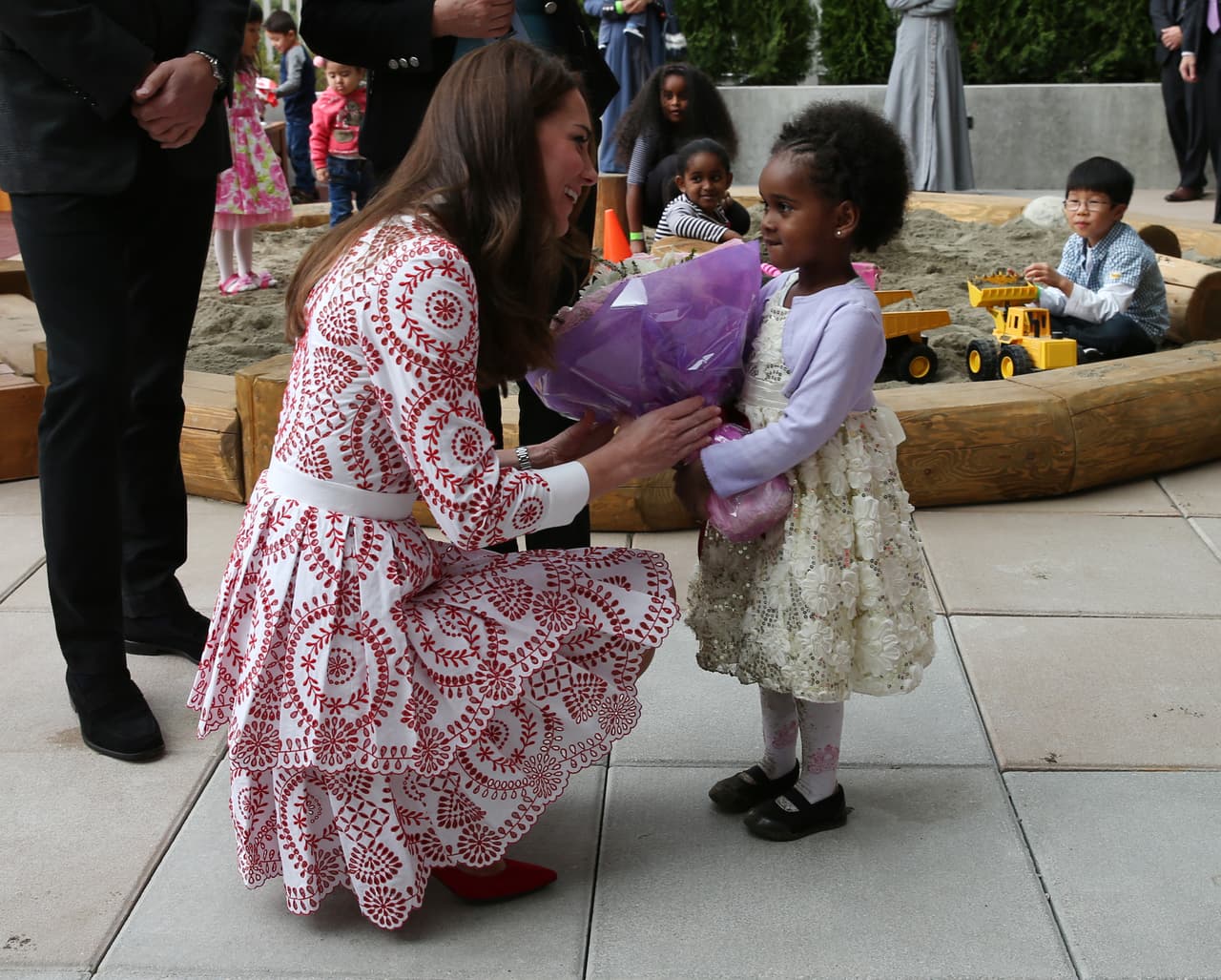 En Columbia Británica una niña recibe a Middleton con un ramo de flores en su visita al Servicio Social de Inmigrantes.