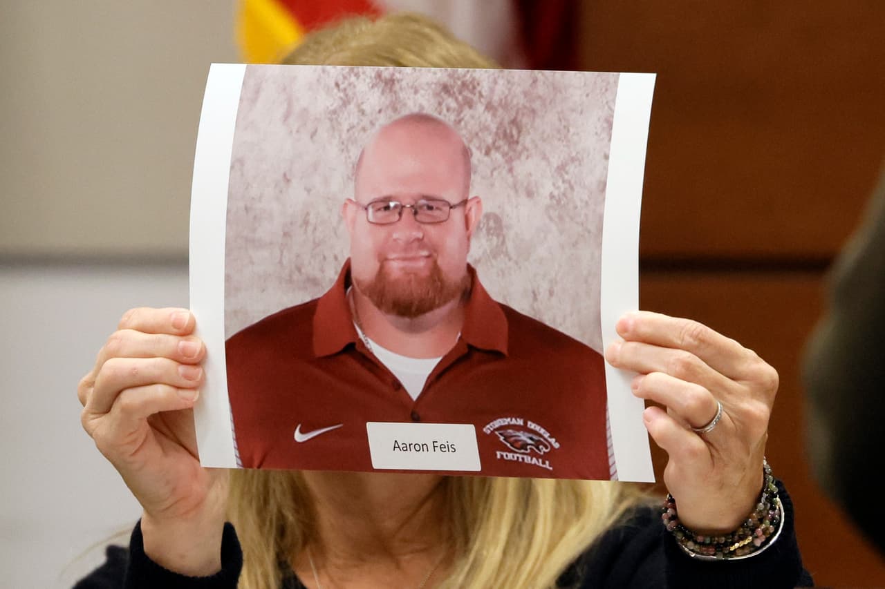 Marilyn Binner, una amiga de la familia, sostiene una fotografía de Aaron Feis mientras lee un escrito de su viuda, Melissa, durante el juicio contra el responsable del tiroteo de Parkland, el pasado 2 de agosto de 2022.