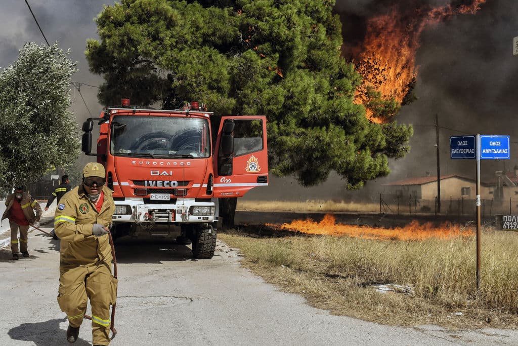 Los bomberos luchan contra el incendio forestal en el asentamiento de Irini, cerca de la ciudad turística de Loutraki, a unos 80 kilómetros al este de Atenas, el 17 de julio de 2023.
