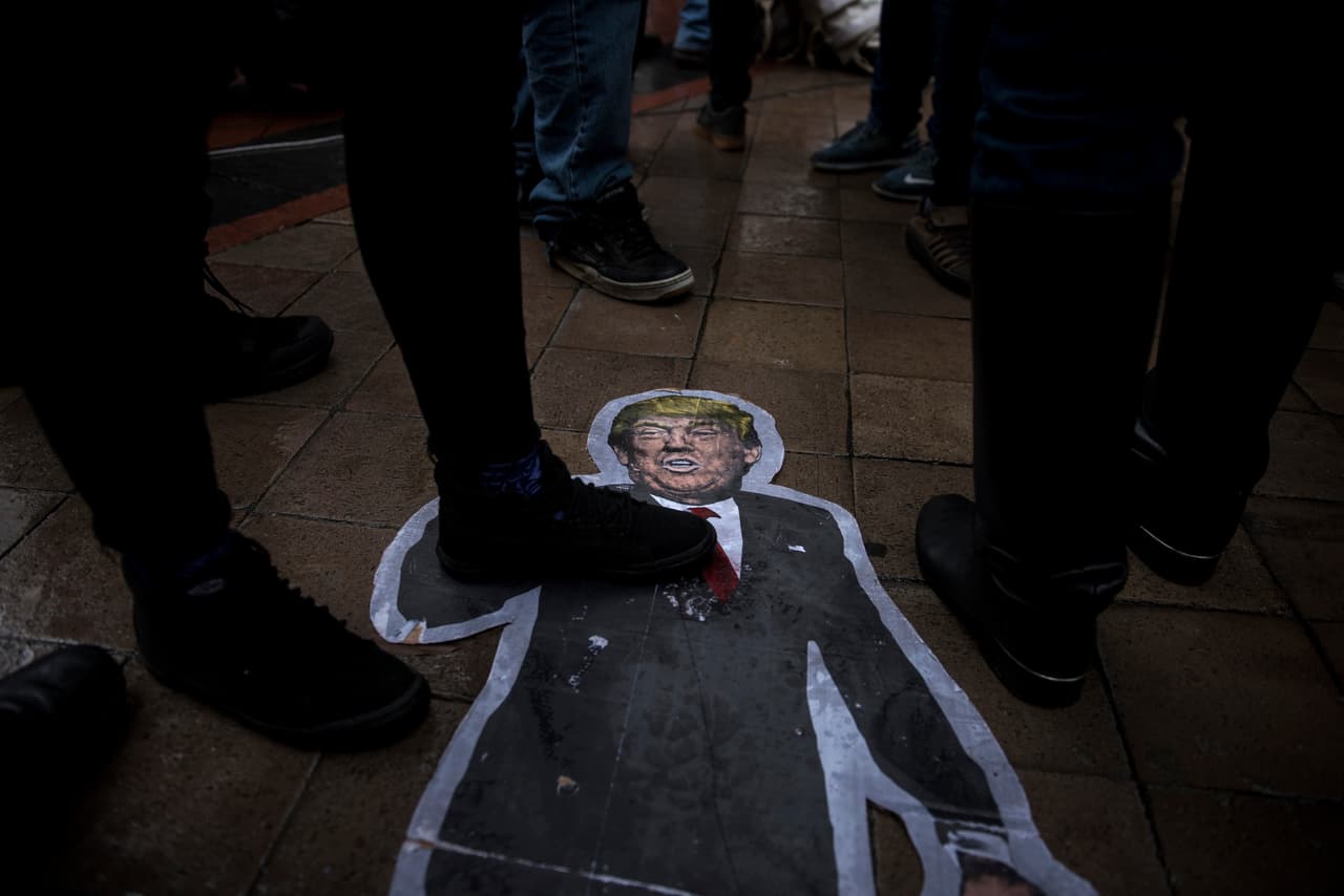 Un recorte del presidente de los Estados Unidos, Donald Trump, se ve en el suelo mientras los activistas se reúnen frente al hotel Trump International para protestar contra el oleoducto Dakota Access.