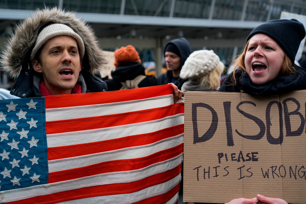 En las pancartas, los manifestantes llaman a "desobedecer" la orden ejecutiva y permitir la entrada al país de todos cuantos han sido detenido en las terminales de Estados Unidos desde este viernes por la tarde.