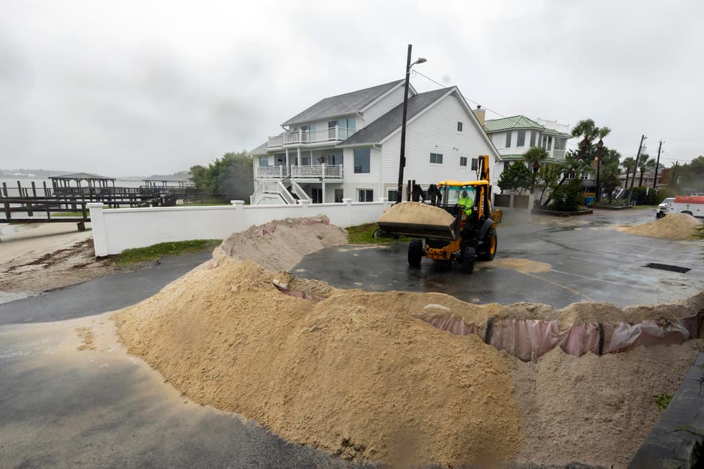 Trabajadores del Departamento de Obras Públicas como Bruce Saunders también trabajaron hasta el último minuto en Tybee Island, acumulando arena para proteger viviendas de la marejada ciclónica.