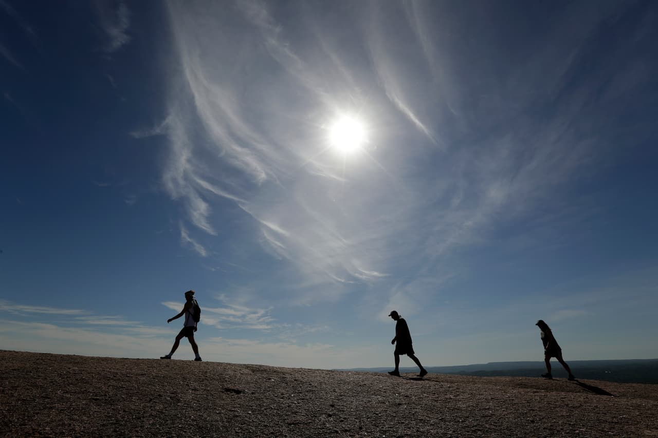 Siguiendo las reglas de distanciamiento social y con máscaras, los residentes de Fredericksburg, Texas, caminaron por el parque Enchanted Rock el 20 de abril. Ese día se reabrieron al público los parques administrados por el estado.
