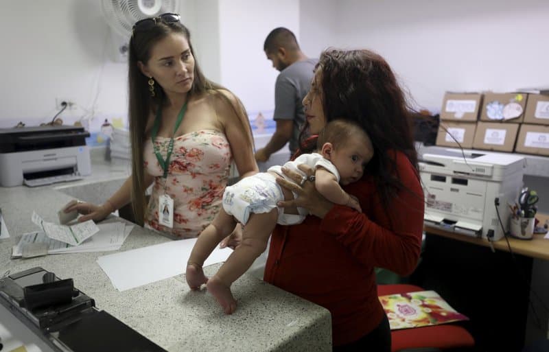 Arelys Pulido holds her two-month-old daughter Zuleidys Antonella Primera as they are processed for her baby's birth certificate in Colombia.