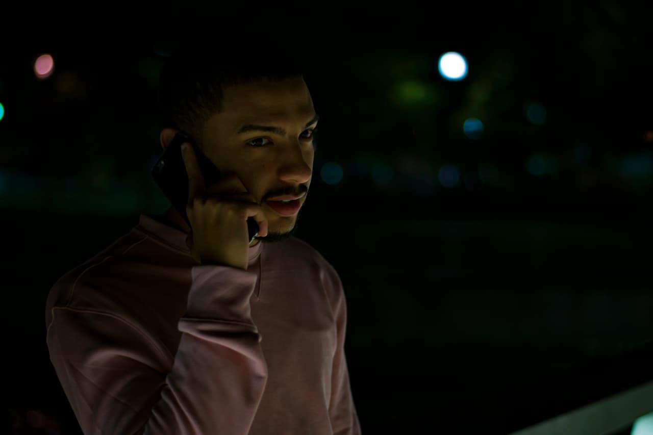 Young hispanic male speaking on the phone.