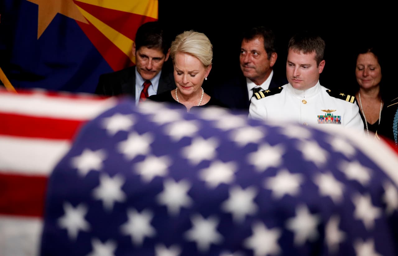 En el centro de la imagen, Cindy McCain, la esposa del fallecido senador, junto a su hijo Jack frente al féretro de su esposo en el Capitolio de Arizona en Phoenix.