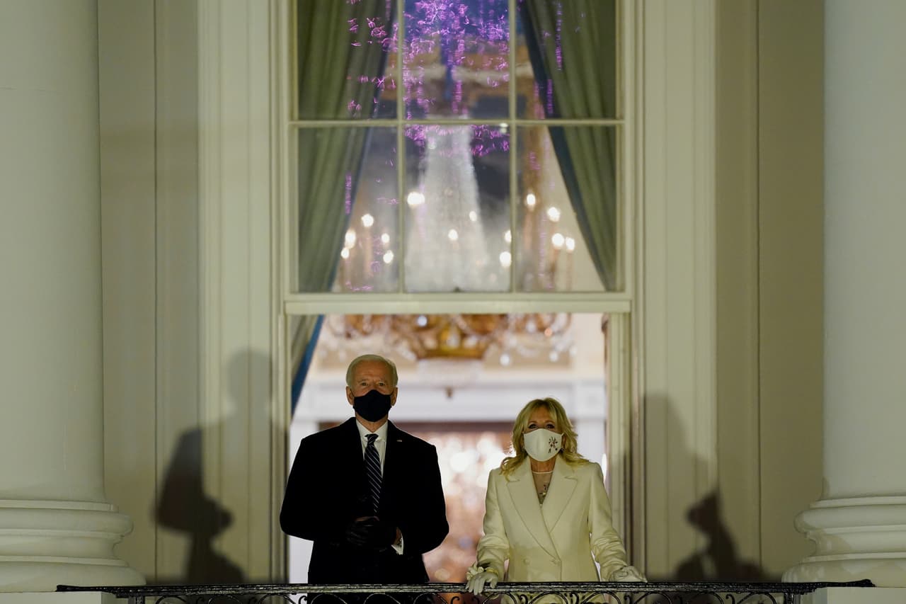 Joe y Jill Biden mirando los fuegos artificiales desde un balcón de la Casa Blanca, el apoteósico cierre de la celebración.
