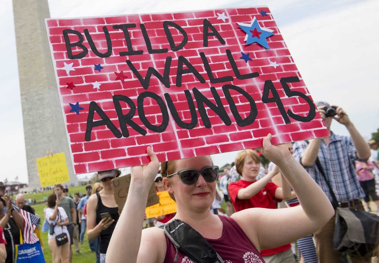 <b>"Construyan un muro alrededor de (el presidente número) 45",</b> dice el cartel en DC en referencia a la idea de Trump de construir un muro en la frontera con México.