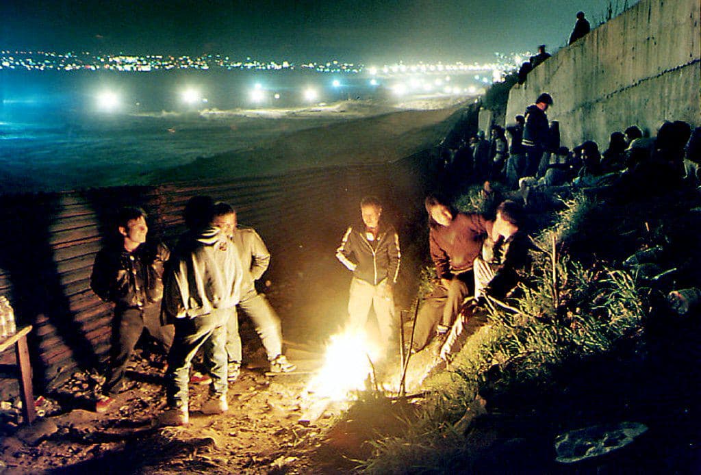 Un campamento de inmigrantes junto a la frontrera en Tijuana, que esperan el mejor momento para intentar cruzar a Estados Unidos, el 6 de marzo de 1995. A lo largo de 15 años, entre 1990 y 2005, Estados Unidos construyó unas 11 bardas metálicas, generalmente de tramos cortos, para dificultar el cruce de indocumentados en áreas urbanas en las comunidades fronterizas.