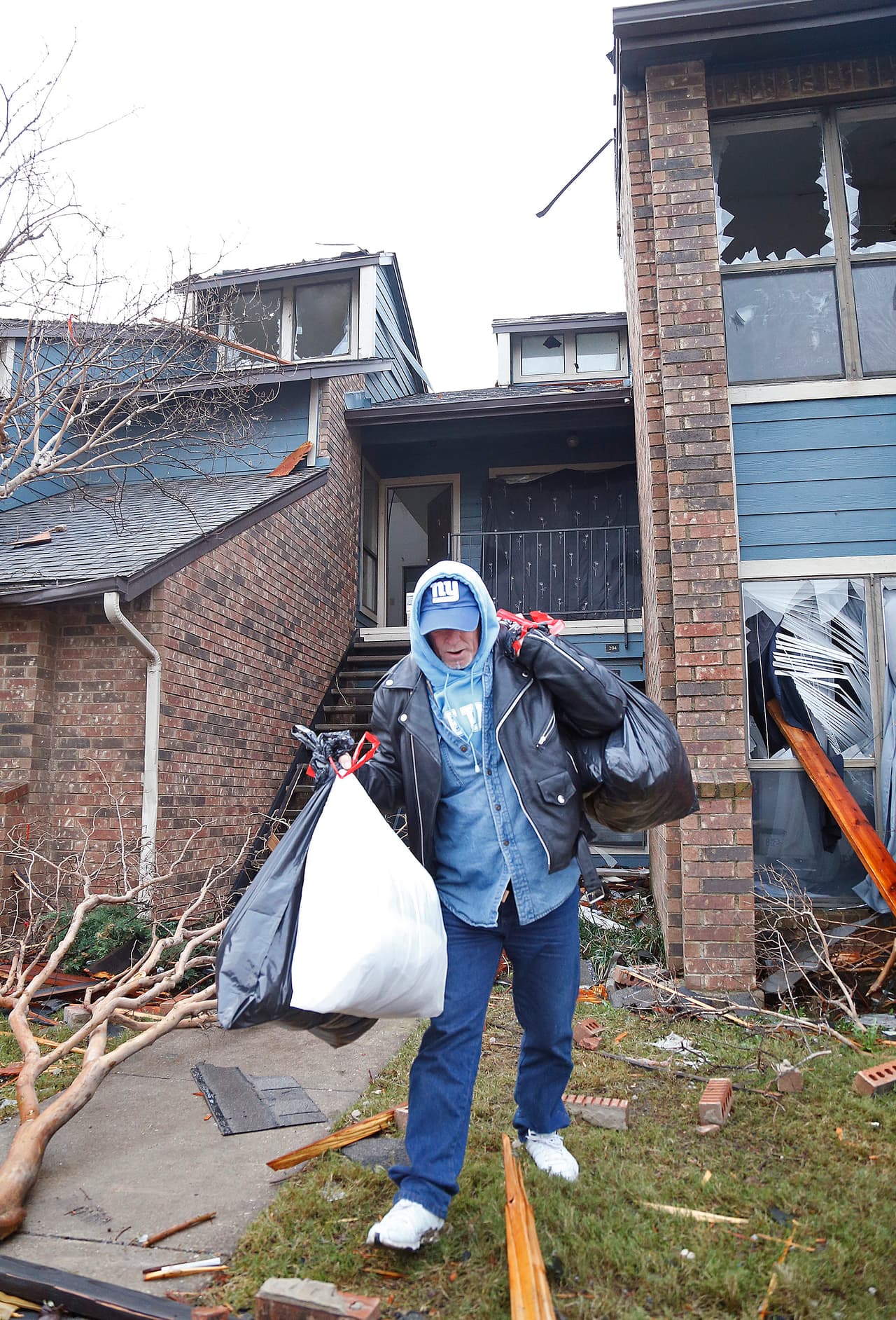 John Lambert, de 54 años, rescata algunas de sus pertenencias en bolsas de basura.