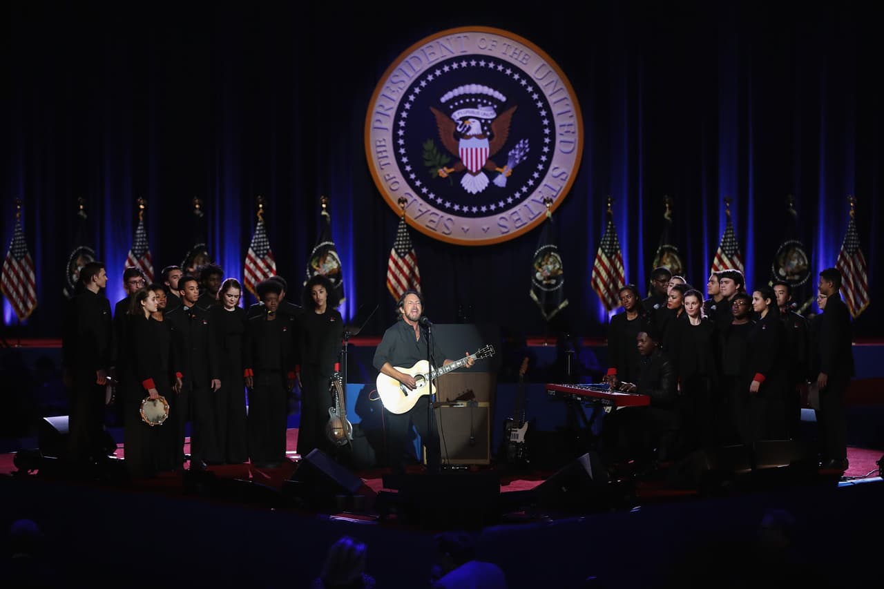 El cantante Eddie Vedler da un pequeño concierto junto al coro de niños de Chicago en el escenario donde Barack Obama dará su último discurso.