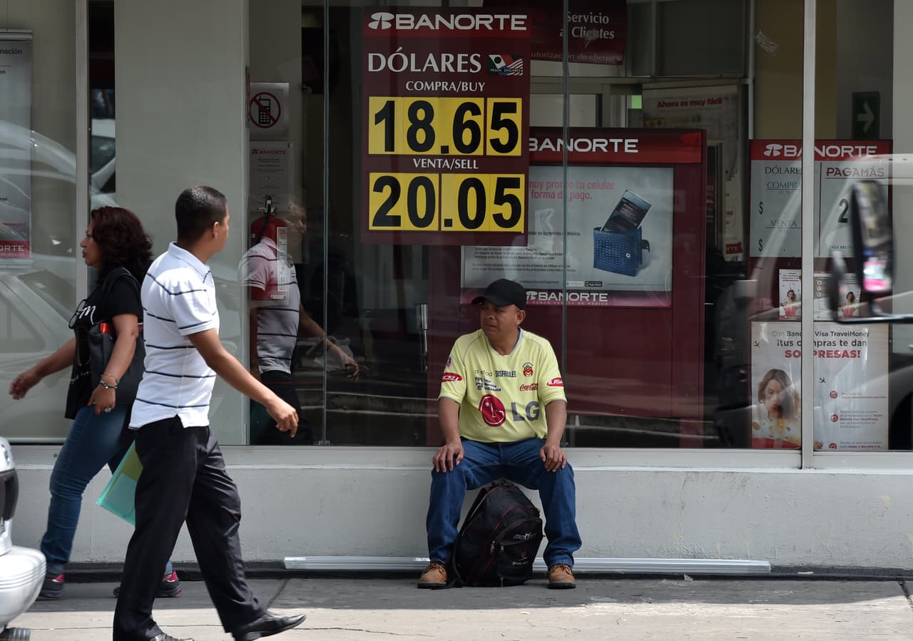 Esta fotografía de un banco de la capital mexicana es del jueves 22 de septiembre de 2016. Un día antes, el presidente Enrique Peña Nieto había culpado de la caída del peso al entonces candidato republicano a la presidencia de EEUU, Donald Trump, por sus declaraciones virulentas contra México; a la caída de los presos de petróleo y al temor de que Reserva Federal de Estados Unidos elevara sus tasas de interés. (Yuri Cortez / AFP)
