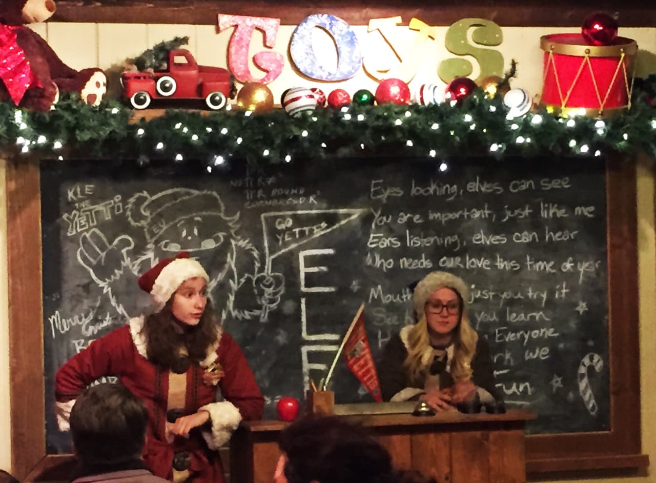 Los ninos entran a un salon de clases de la Universidad de Elf donde les dan la oportunidad de convertirse en Elf honorario.