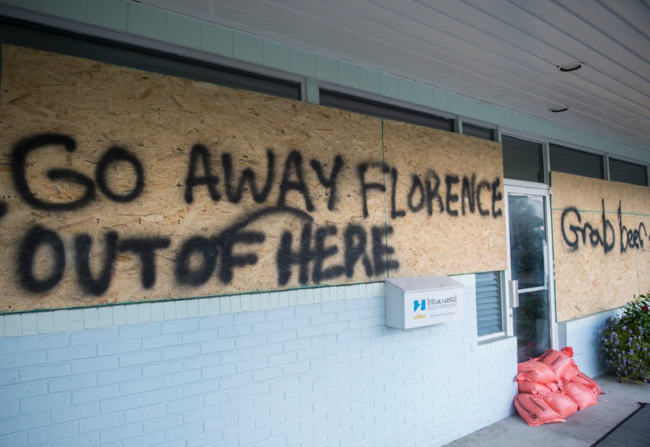 "Vete lejos Florence”, se lee en uno de los paneles que protegen un comercio en Wrightsville Beach, Carolina del Norte. Las autoridades advierten los peligros de las copiosas lluvias y marejadas ciclónicas que producirá el huracán.