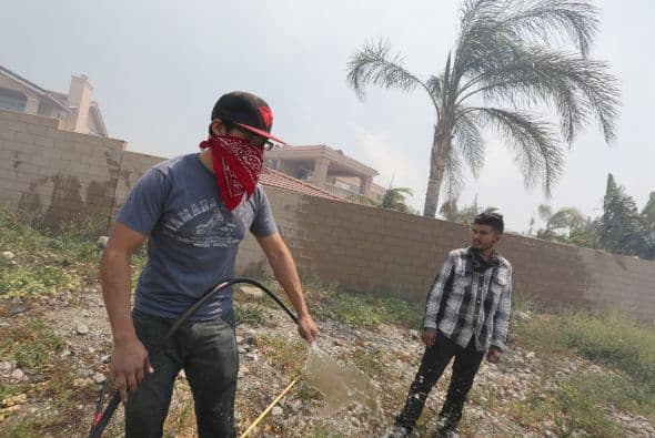 Algunos habitantes trataban de mitigar el fuego en los alrededores de sus casas.