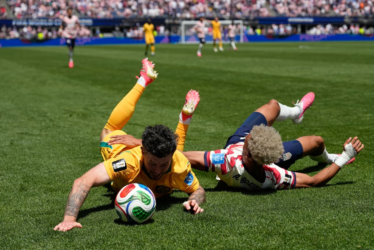 Aiden O'Neill, de Australia (izquierda), y Antonee Robinson, de Estados Unidos, caen al suelo durante el partido de fútbol del Grupo D de la Copa Mundial entre Estados Unidos y Australia en Seattle, el viernes 19 de junio de 2026.