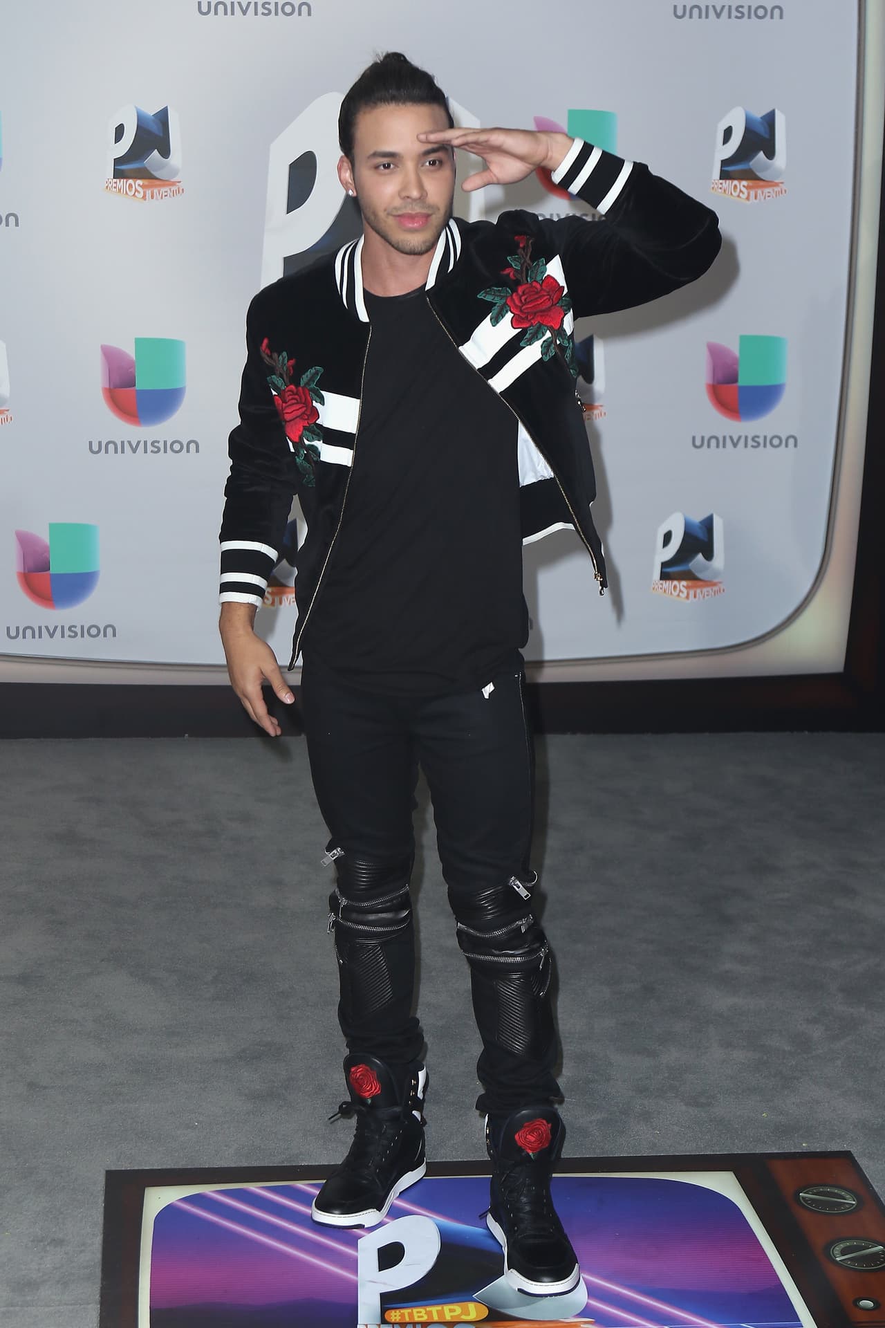 El cantante eligió una chamarra y pantalón negros con motivos blancos y rojos.