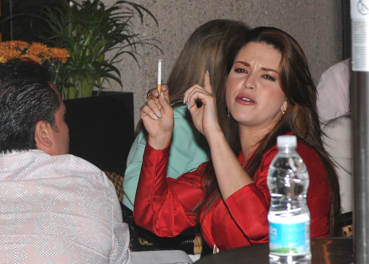 Alicia Machado parecía que no quería ser descubierta con su cigarro en la mano.