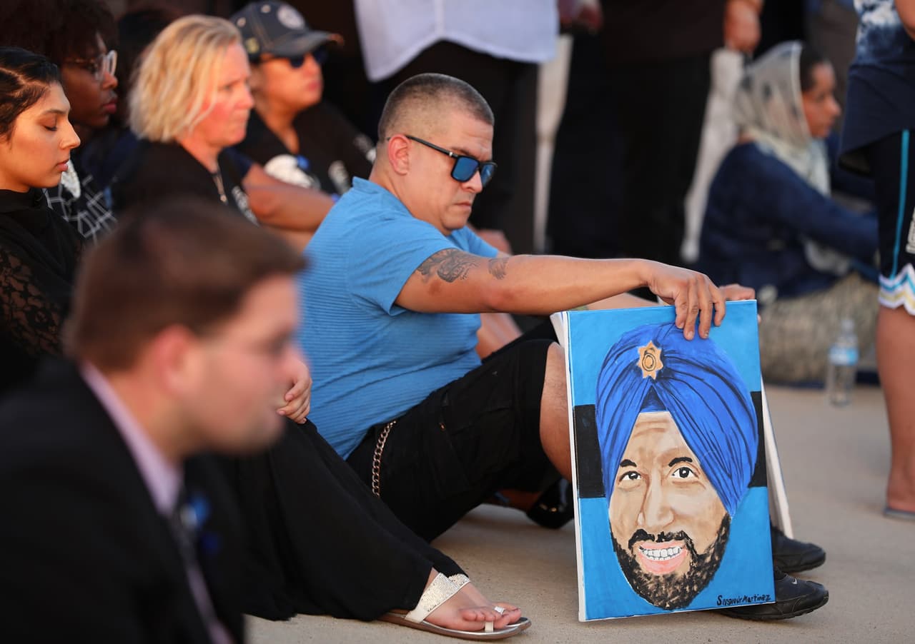 Entre los asistentes hubo personas que le rindieron un homenaje personal, como el hombre en la foto que pintó el retrato de oficial Sandeep Dhaliwal.