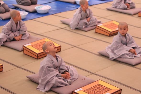 Un grupo de niños rinden honores a Buda. Se afeitaron la cabeza en el templo Chogye.