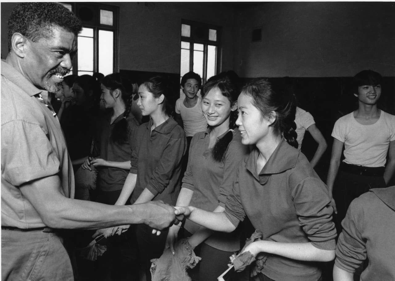Alvin Ailey saludando a jóvenes bailarines chinos en una visita a Beijing el 30 de octubre de 1985.