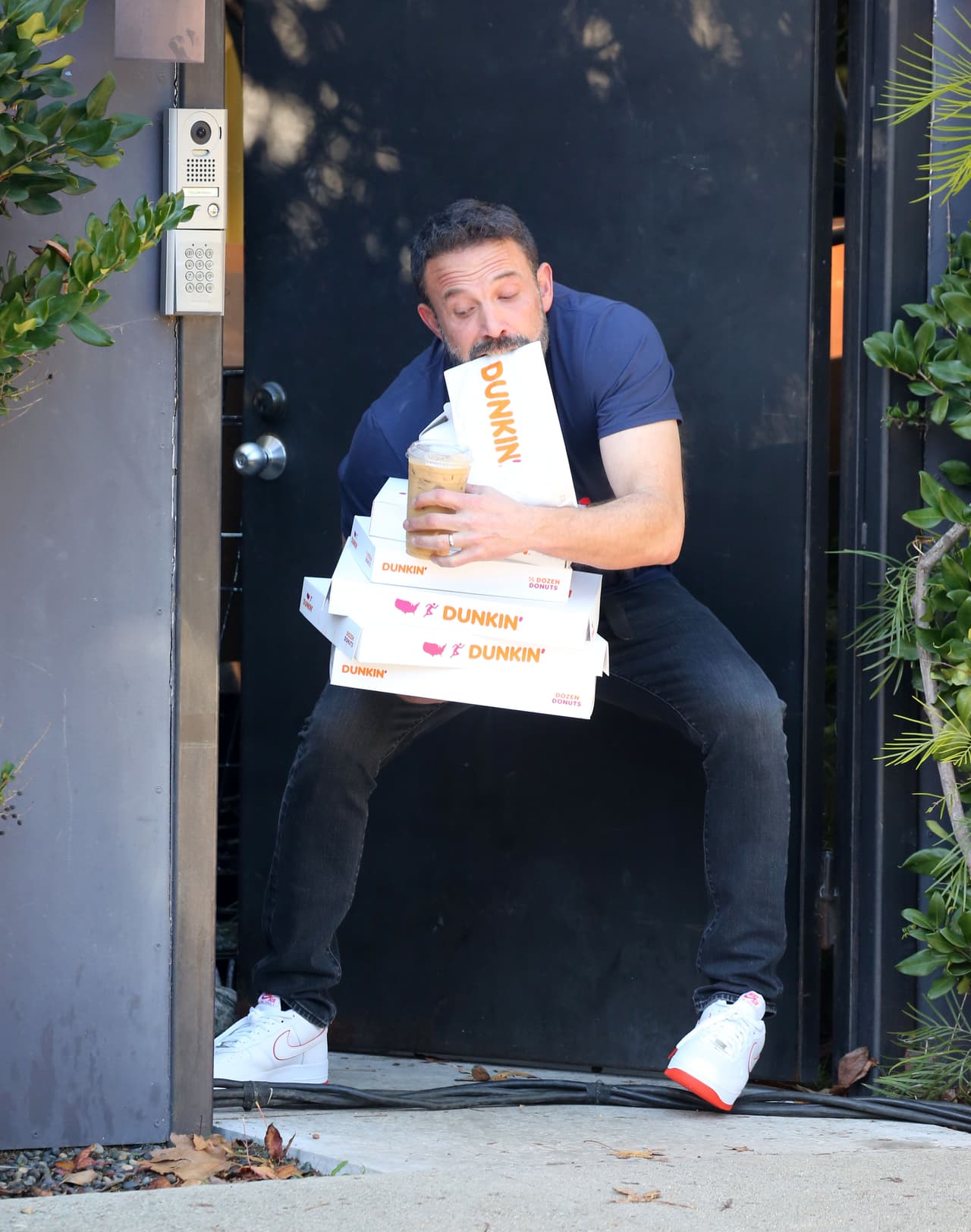 Ben Affleck cargando su pedido de donas y café.
