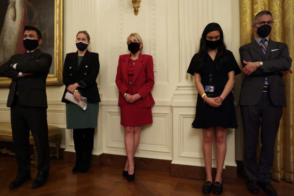 Otro de los objetivos prioritarios, explicó Biden, es conseguir que se reanuden las clases lo antes posible. El personal escolar y los profesores son uno de los objetivos prioritarios de la vacunación, detalló. En la imagen, la primera dama, la doctora 
<a href="https://www.univision.com/temas/jill-biden">Jill Biden (al centro)</a>, quien es profesora, mientras escuchaba el mensaje del presidente.