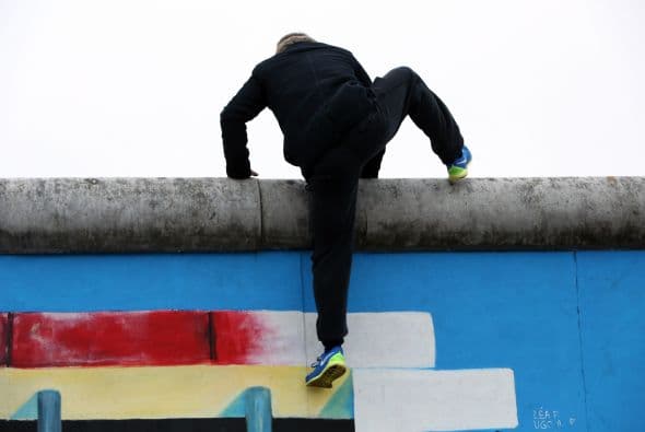 Un artista de circo se sube por encima de la East Side Gallery, una sección del antiguo muro de Berlín, durante las celebraciones por el 25 aniversario de la caída del muro.