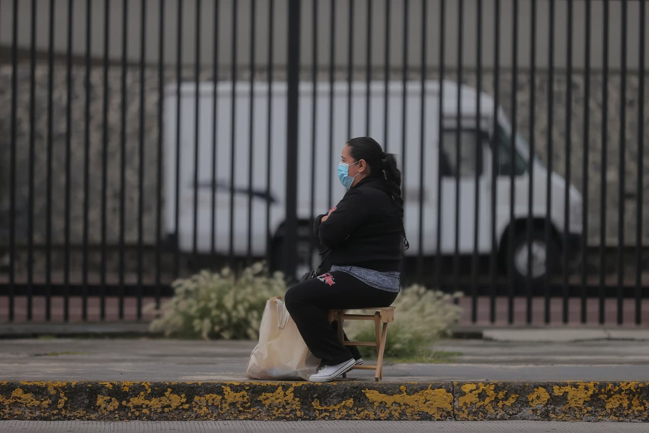 Una señora espera sentada fuera del estadio mientras un familiar realiza el examen de admisión. Fue una cita más solitaria de lo que acostumbra a ser cada año: 
<b>Las multitudes de padres y familias enteras que generalmente acompañan a los estudiantes y aguardan afuera en solidaridad recibieron instrucciones por parte de la universidad de quedarse en casa para evitar aglomeraciones que podrían propagar el coronavirus.</b>
<br>
<br>