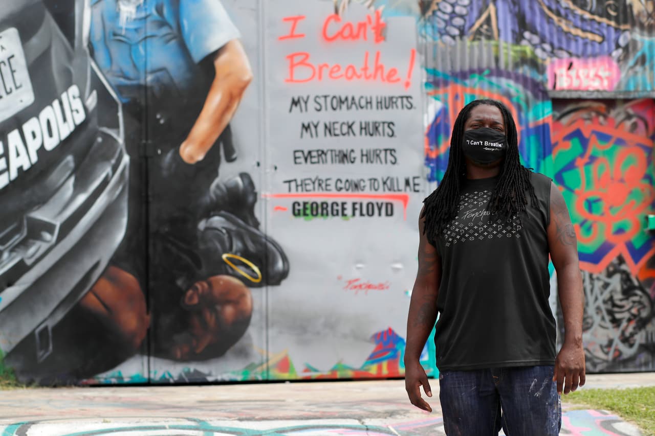 <b>Dallas, Texas. </b> El artista Theo Ponchaveli posa frente al su mural mural de Floyd, que recrea la escena del afroamericano bajo la rodilla del policía.
