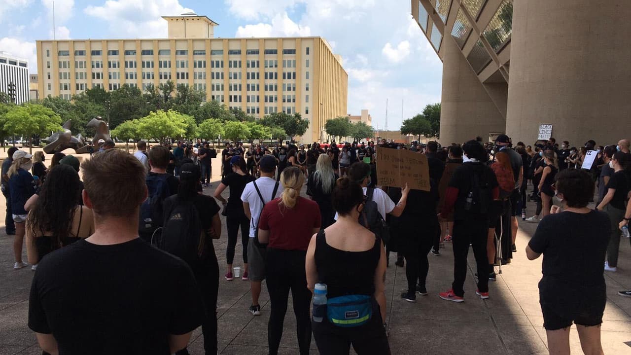 Enfrente del edificio de la alcaldía de Dallas cientos de personas se reunieron portando pancartas en protesta por el fallecimiento de Floyd.