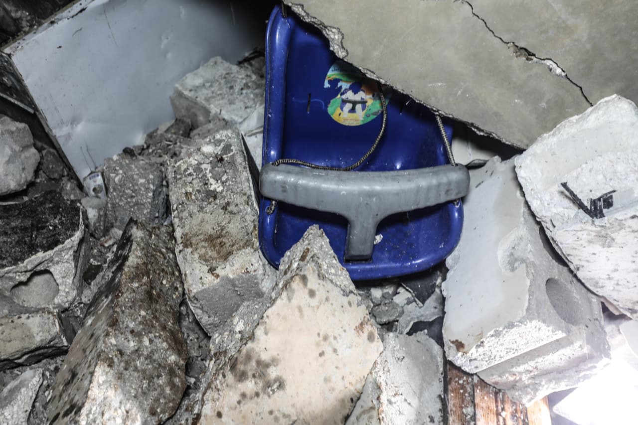 En una de las paredes dañadas colgaba aún un columpio infantil de plástico azul. La cocina quedó ennegrecida por el fuego.