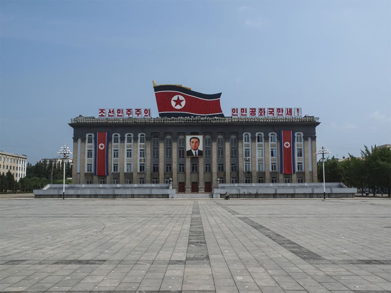 <b>Fachada de la plaza de Kim Il Sung. </b>Ubicada en el centro de la ciudad, es la más importante del país. A muchos turistas les resulta familiar debido a que es el lugar cuyas imágenes aparecen en los medios internacionales cuando informan de los desfiles en Pyongyang. A las afueras de la ciudad, con espectaculares vistas de la urbe desde el monte, se encuentra el Cementerio de los Mártires Revolucionarios, que conmemora a los héroes nacionales del país.