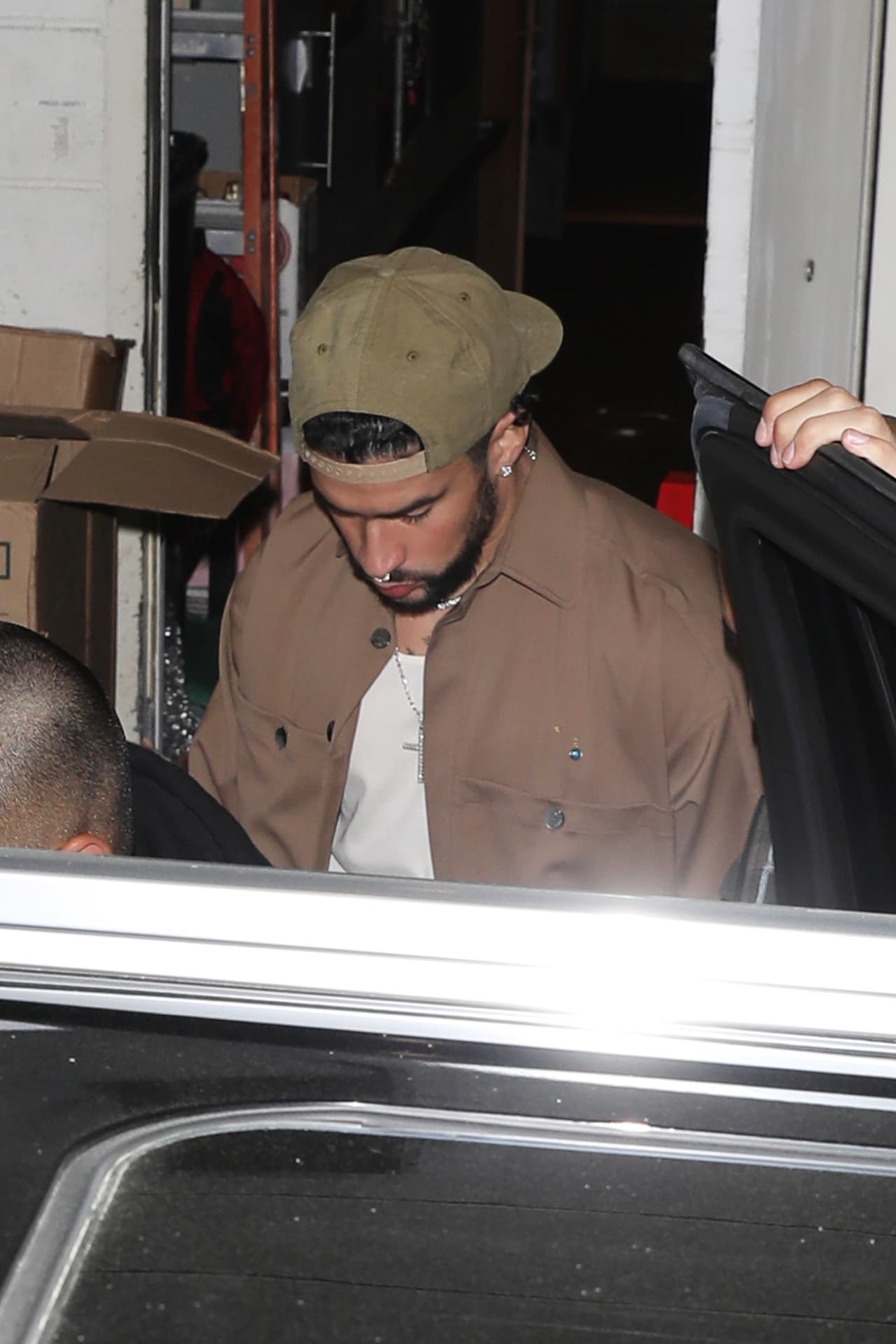 Fue guiado hasta su auto mientras caminaba con la cabeza agachada y con hombres tratándolo de cubrirlo con una sombrilla, reportó The Grosby Group.